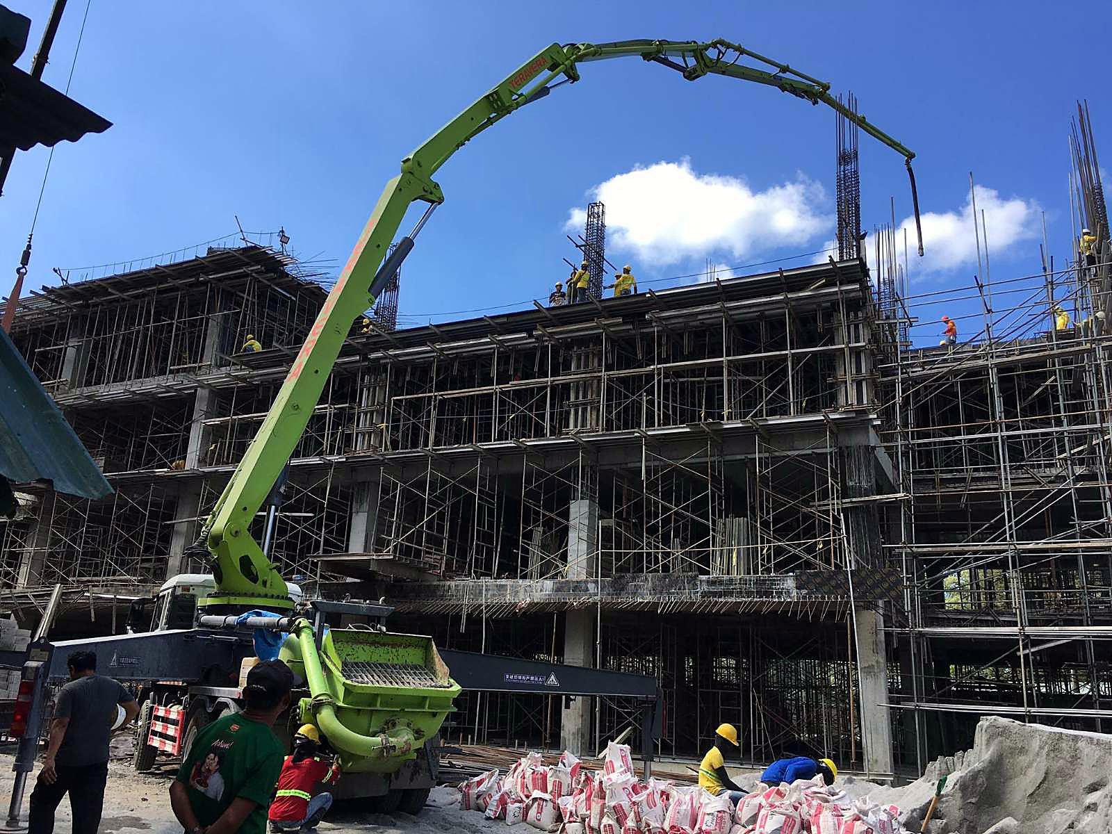 Concrete pump boom placing concrete on a multi-storey building under construction