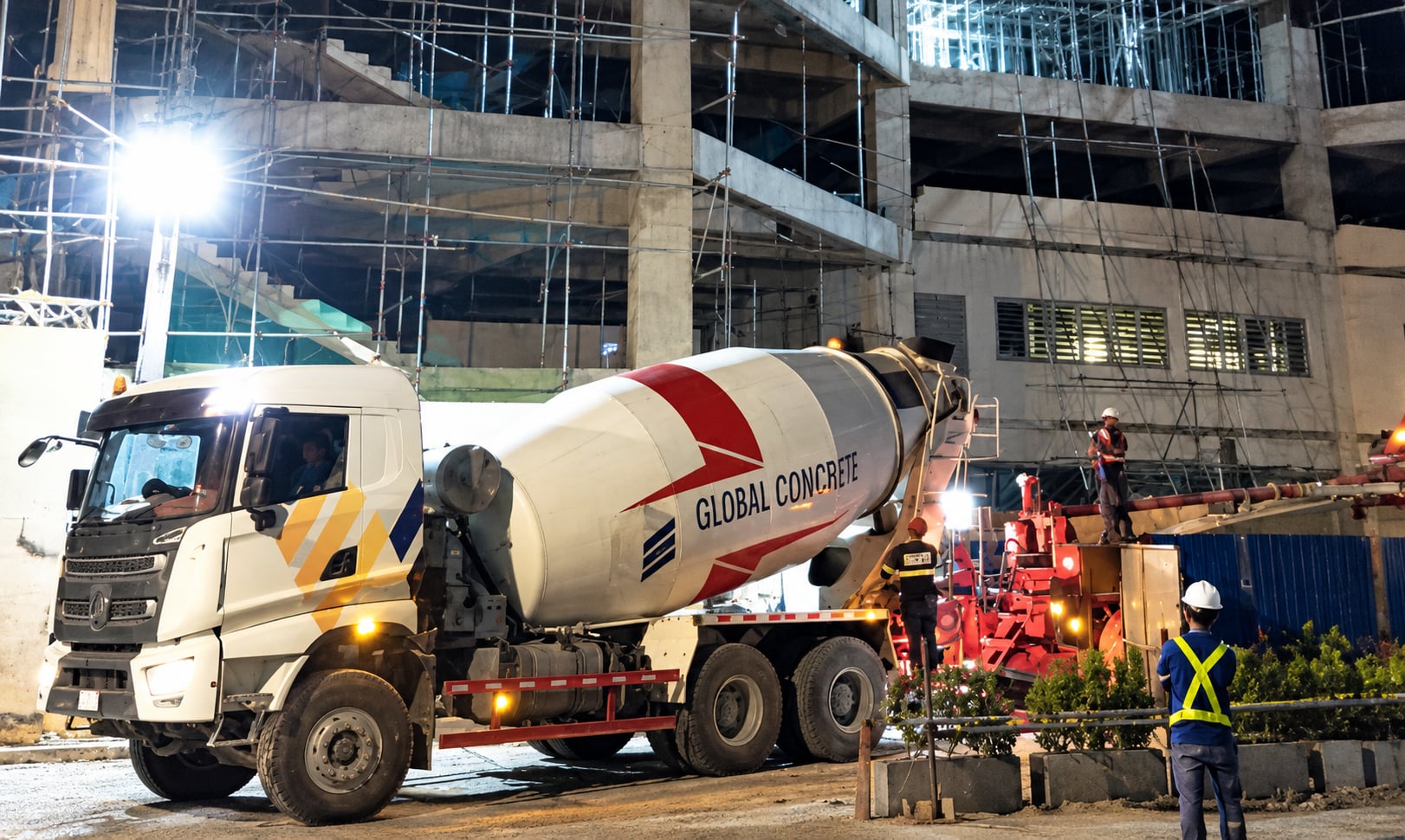 GCDC mixer truck and concrete pump during a night pour at a building site