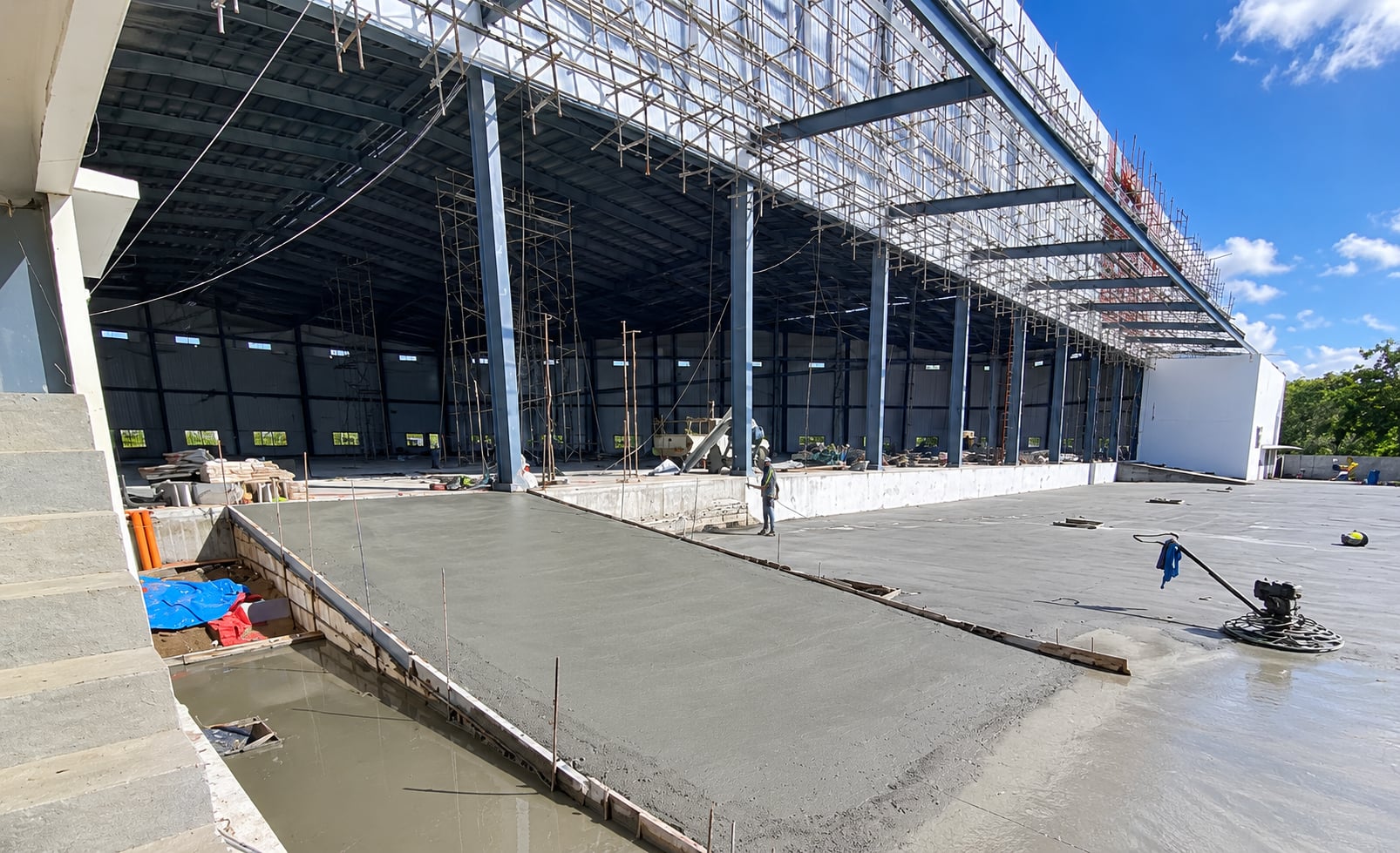 Crew screeding a concrete slab at a warehouse under construction